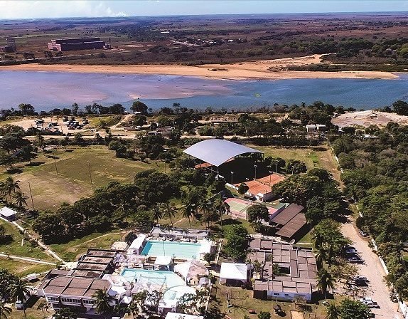 Vista aérea do clube, com as piscinas, as quadras e o rio ao fundo